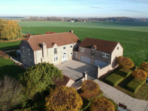 Grande maison en briques en forme de L avec une cour intérieure et une vue imprenable sur les cultures et les champs